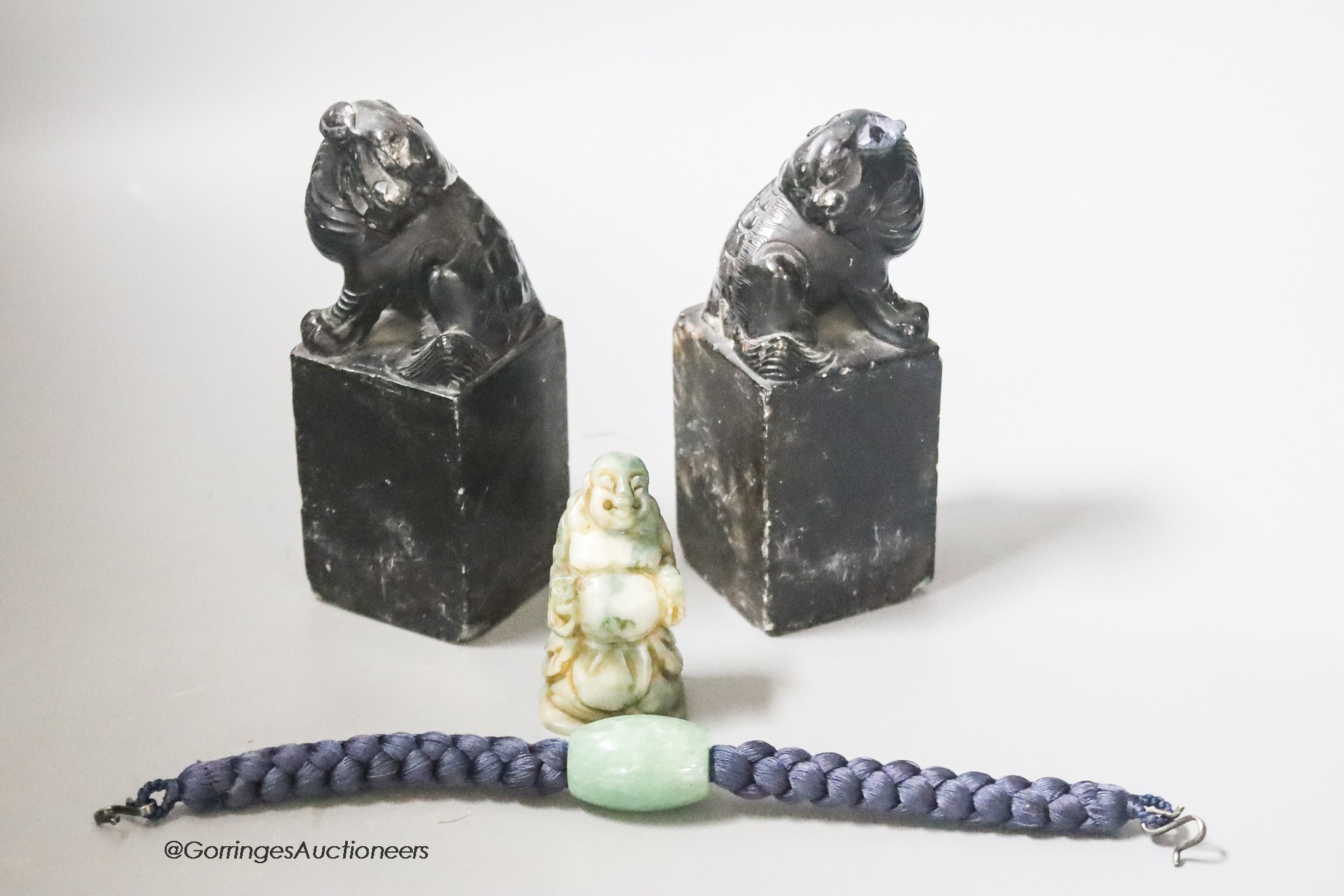 A pair of hardstone carved Temple dogs, height 13cm, a Buddha and a jade bead bracelet